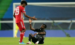 L'attaquant du Bayern Munich, Kingsley Coman (g), console l'attaquant ivoirien de Lyon, Maxwel Cornet, déçu aprÚs la défaite de son équipe en demi-finale de la Ligue des champions, à Lisbonne, le 19 août 2020