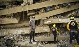 Raul Alvarado (g) cherche des proches disparus sous les décombres de l'immeuble OPP 26 de 16 étages ç Carabellada, dans l'Etat de La Guaira, le 6 juillet 2026 au Venezuela