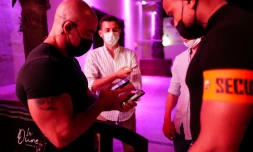 Un vigile contrôle les pass sanitaire d'un client à l'entrée d'une boite de nuit à La Grande Motte (sud de la France), le 9 juillet 2021