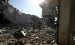 Des Syriens au milieu des destructions dans la localité de Saqba, dans l'enclave rebelle de la Ghouta orientale, bombardée par le régime syrien, le 9 mars 2018