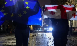 Des manifestants brandissent des drapeaux de l'Union européenne et de la Géorgie lors de la cinquième nuit consécutive de mobilisation contre le report des négociations d'adhésion à l'UE, le 3 décembre 2024 à Tbilissi, en Géorgie