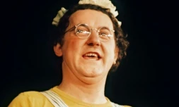 Le chansonnier-fantaisiste Coluche, vêtu de sa traditionnelle salopette rayée et d'un tee-shirt, se produit sur la scène de l'Olympia à Paris, le 18 février 1975