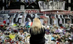 Une femme se recueille devant un mémorial improvisé composé de fleurs, de bougies et de messages, place de la République à Paris, le 17 novembre 2015, en hommage aux victimes des attentats du 13 novembre 2015
