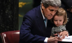 Le secrétaire d'Etat américain John Kerry signe l'accord sur le climat, tenant sa petite-fille, le 22 avril 2016 à l'ONU à New York