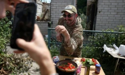 Ukrainian serviceman and influencer Ruslan Mokrytskyi poses for the camera as he cooks pasta as his fellow soldier records a video of him for Tik Tok in an undisclosed location in the Donetsk region, on July 27, 2024, amid the Russian invasion in Ukraine. At the front since the start of the war in 2022, Mokrytskyi needed a form of escape while being under constant fire. "After missions, there were, let's say... many horrible and stressful images," he said, hesitantly. "I needed to recuperate mentally." He tried to forget the horrors by plunging into films, music, reading, going on walks despite the bombs. But nothing worked. "I got to the point where I told myself that it would be cool to film myself making fries for instance," the soldier said. The success of that idea exceeded his expectations: his fries video got three million views. Encouraged, Mokrytskyi involved friends from his battalion, who would call their wives to get ideas for recipes. He then realised he was not only helping his own mental health bRouslan Mokrytsky, soldat et influenceur ukrainien le 25 juillet 2024 dans la région de Donetsk