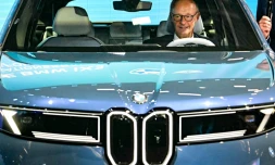 Le chancelier allemand Friedrich Merz assis dans une BMW IX3 sur le stand du constructeur automobile lors de l'ouverture du Salon international de l'automobile IAA, le 9 septembre 2025 à Munich, dans le sud de l'Allemagne
