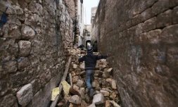 Un enfant se fraye un chemin à travers les ruines de bâtiments à Alep, le 17 décembre 2016.