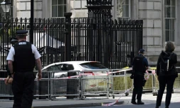 Des policiers devant une voiture qui a percuté les grilles de Downing Street, le 25 mai 2023 à Londres