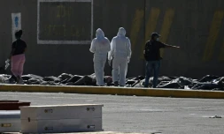Des experts médicolégaux procèdent à l'identification de corps étendus au sol dans une morgue de fortune située dans le port de La Guaira, au Venezuela, le 29 juin 2026