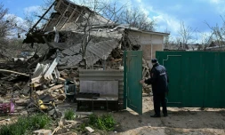 Un policier russe inspecte une maison détruite aprÚs une attaque aérienne à Yasynuvata, dans la région ukrainienne de Donetsk contrÎlée par la Russie, le 11 avril 2026