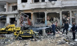 Des Syriens au milieu des dĂ©combres le 21 fĂ©vrier 2016 Ă Al-Zahraa un quartier de Homs oĂč 59 personnes ont Ă©tĂ© tuĂ©es dans des attentats