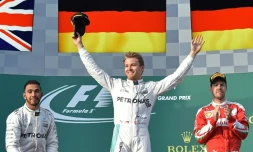 L'Allemand Nico Rosberg (Mercedes) bras levés sur le podium, fête sa victoire au GP d'Australie devant son coéquipier Lewis Hamilton (g) et Sebastian Vettel (Ferrari), le 20 mars 2016 à Melbourne