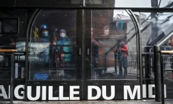 Des skieurs portent des masques de protection dans la cabine du téléphérique de l'Aiguille du Midi, le 16 mai 2020 à Chamonix