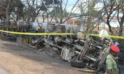 Un membre des forces de sécurité tanzanienne surveille la carcasse d'un camion-citerne accidenté, dont l'explosion a fait plus de 60 morts parmi les passants qui tentaient de le siphonner, le 10 août 2019, à Morogoro.