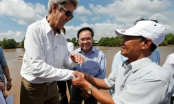 Le secrétaire d'Etat américain John Kerry sert la main de l'ancien guerillero Vo Van Tam le 14 janvier 2017 sur le delta de la rivière du Mekong