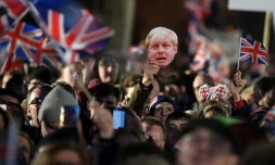 Des partisans du Brexit agitent des drapeaux britanniques et un masque du Premier ministre Boris Johnson à Londres le 31 janvier 2020