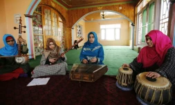 Des jeunes femmes soufies jouent de la musique traditionnelle sous l'oeil de leur professeur, le 25 février 2017 à Srinagar, au Cachemire indien