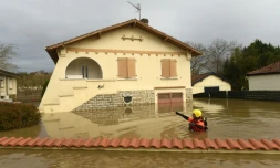 Un pompier passe dans une zone complètement inondée de Peyrehorade, le 14 décembre 2019 dans les Landes