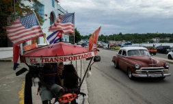 Un tricyle-taxi orné de drapeaux américains, dans une rue de La Havane, le 19 juin 2026 à Cuba
