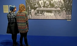 Des visiteurs d'une exposition en Pologne consacrée à Frida Kahlo et son époux contemplent une photo d'une toile disparue depuis plus d'un demi-siècle de l'artiste mexicaine, La table blessée, le 28 novembre 2017 à Poznan