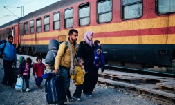 Une famille, parmi d'autres migrants, s'apprête à monter dans un train se dirigeant vers la Serbie après avoir passé la frontière gréco-macédonienne près de Gevgelija, en Macédoine, le 16 novembre 2015
