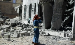 Un homme se tient devant un immeuble détruit par un bombardement de la coalition menée par l'Arabie saoudite, à Sanaa le 28 octobre 2015