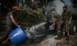 Des chasseurs installent des points d'eau pour abreuver les animaux après les incendies qui ont ravagé la zone, le 23 juillet à Pyla-sur-Mer (Gironde) 
