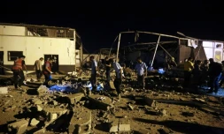 Des secouristes retirent des corps des décombres d'un hangar visé par un raid aérien dans un centre de détention de migrants à Tajoura prÚs de la capitale libyenne Tripoli, le 3 juillet 2019