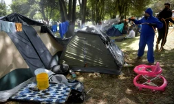 Un agent désinfecte un camp improvisé de migrants vénézuéliens à Bogota, le 9 juin 2020