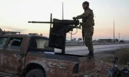 Un combattant anti-régime à l'arrière d'un pick-up équipé d'une arme sur l'autoroute entre Alep et Raqa, le 2 décembre 2024 dans le nord de la Syrie