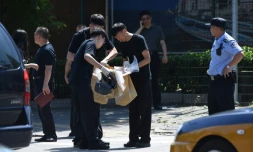 Des agents de sécurité (c) relèvent des indices après une explosion devant l'ambassade des Etats-Unis à Pékin, le 26 juillet 2018