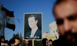 Des manifestants brandissent une photo du président syrien Bachar al-Assad à Qamichli, dans le nord du pays, le 23 décembre 2018 demandant la protection de l'armée
