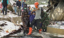 Des secouristes transportent des sacs mortuaires contenant des personnes décédées dans le village de Klatanlo sur l'ßle de FlorÚs, en Indonésie, le 4 novembre 2024, aprÚs l'éruption du volcan Lewotobi Laki-Laki