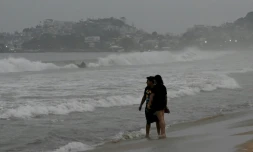 Des promeneurs sur une plage d'Acapulco avant l'arrivée de l'ouragan Otis, le 24 octobre 2023 au Mexique