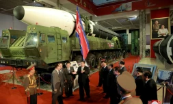 Le leader nord-coréen Kim Jong Un devant un missile balistique intercontinental présenté dans une exposition d'armement, le 11 octobre 2021 à Pyongyang