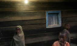 Des enfants devant une maison éclairée par l'électricité à Bugara, le 17 juillet 2016