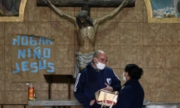 Le pÚre Lorenzo de Vedia remet à une femme les cendres de son époux, décédé du coronavirus, le 31 juillet 2020 à Buenos Aires