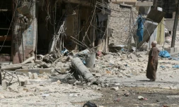 Un habitant du quartier Tariq al-Bab, à Alep en Syrie, inspecte les dégùts causés par des frappes aériennes, le 16 août 2016