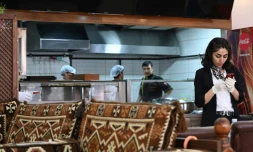 Une serveuse afghane consulte son téléphone dans le restaurant Afghan Kebab à Esenyurt, un distrcit d'Istanbul le 11 avril 2019