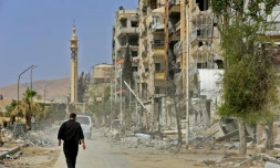 Un homme marchant dans la ville de Douma, théâtre d'une attaque chimique présumée le 7 avril 2018. Photo prise le 20 avril 2018 lors d'une visite organisée par le régime syrien pour des journalistes après qu'il eut chassé les rebelles de Douma.