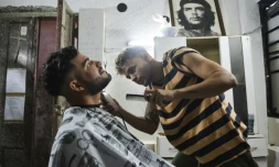 Un barbier taille la barbe d'un client à La Havane, le 7 août 2019