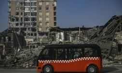 Un minibus passe devant des maisons détruites par un bombardement, le 25 mars 2022 dans un bombardement à Kharkiv, en Ukraines 2022