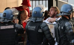 Des policiers font face à des supporters madrilènes avant le coup d'envoi de la finale de la Ligue des champions devant le Stade de France situé à Saint-Denis près de Paris, le 28 mai 2022 