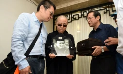 Photographie du Shenyang Municipal Information Office, montrant la femme du dissident chinois Liu Xiaobo, Liu Xia (c) et son frère, Liu Xiaoguang (L), recevant les cendres du défunt après son incinération, le 15 juillet 2015 à Shenyang