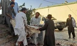 Des hommes transportent un corps après l'attentat dans une mosquée de Kunduz, dans le nord de l'Afghanistan, le 8 octobre 2021