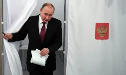 Le président russe Vladimir Poutine sort d'un isoloir lors de la présidentielle russe, le 18 mars 2018 à Moscou