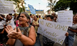 Des manifestants brandissent des pancartes demandant un référendum contre le président Nicolas Maduro, le 21 octobre 2016 à Caracas