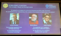 Un écran montre les lauréats du prix Nobel de physique, le Canado-américain James Peebles, et les Suisses Michel Mayor et Didier Queloz, à Stockholm le 8 octobre 2019