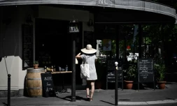Une femme attend sa commande de plats à emporter devant un restaurant, le 27 mai 2020 à Paris