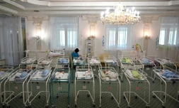 Une infirmière s'occupe de nouveaux-nés parmi la centaine de bébés nés de mères porteuses bloqués en Ukraine par la pandémie, à l'Hôtel Venice à Kiev le 15 mai 2020